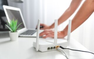 Osoba propojující moderní wi-fi router na světlém stole v obýváku
